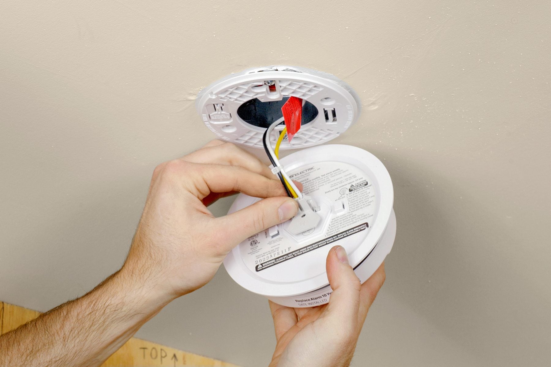 NICEIC certified electrician installing a mains-wired interlinked smoke alarm to BS 5839-6 in a London property
