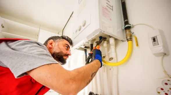 Gas engineer inspecting a boiler making kettling and rumbling noises from magnetite sludge restriction in London