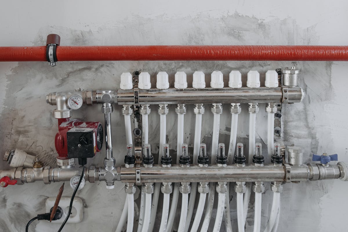 London plumber lagging exposed pipes with foam insulation to prevent frozen pipes and winter bursts in a rental